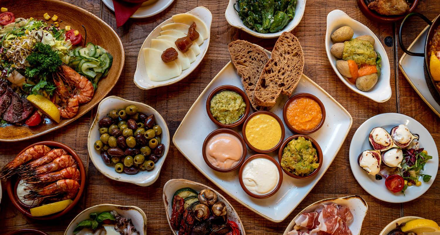 verschiedene Tapas im Tapas Barcelona auf Holztisch angerichtet